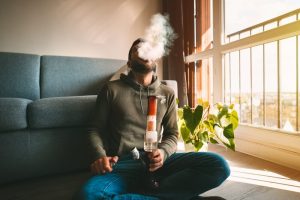 man smoking cannabis from a bong