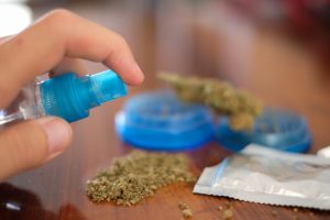 cannabis bud being sprayed with synthetics